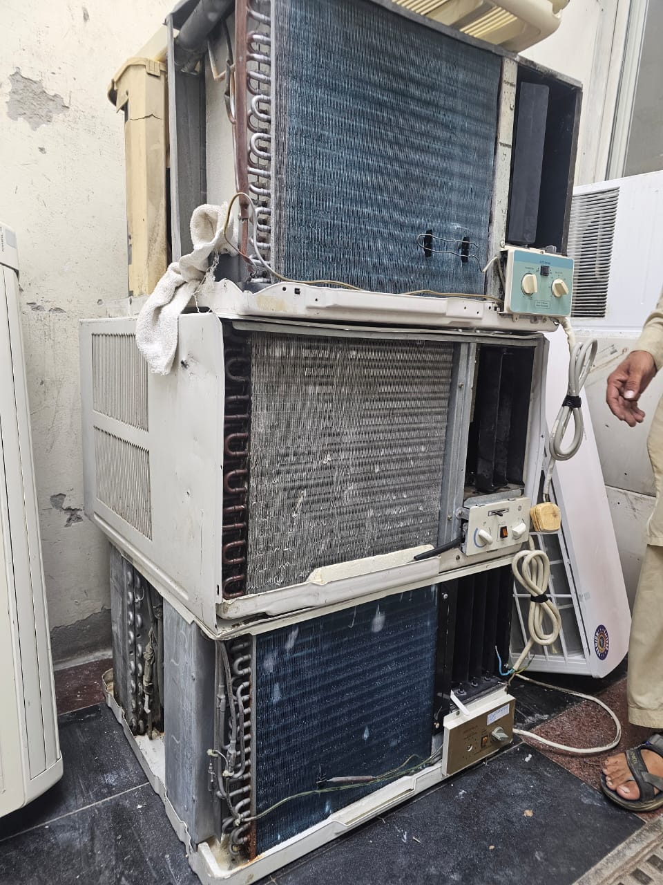 Stacked scrap window AC units with old coils and compressors bought for cash in Dubai UAE