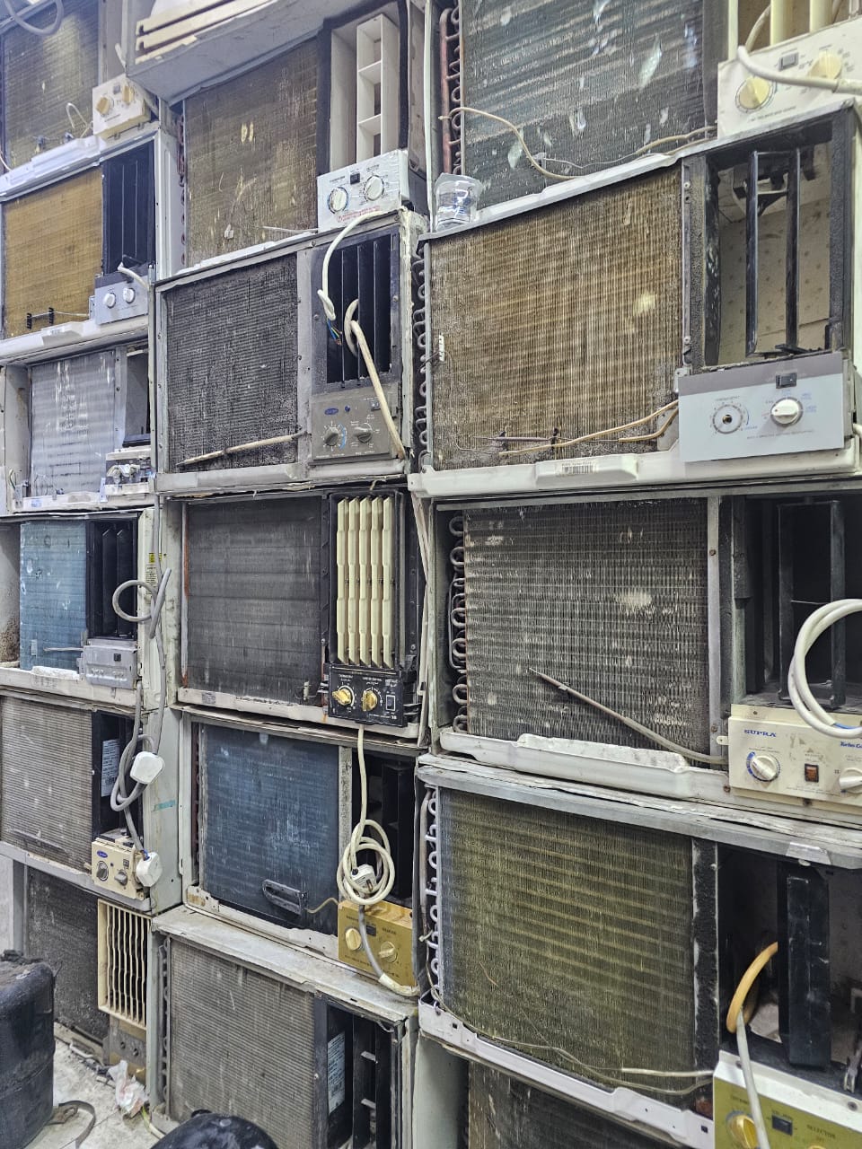 Scrap window AC buyer in Dubai - wall of old dead window air conditioners bought for cash and recycling
